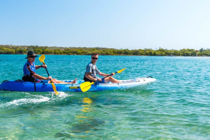 a man riding on the back of a boat in a body of water