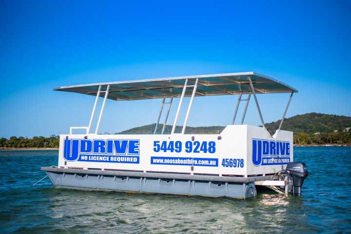 a large blue boat sitting next to a body of water